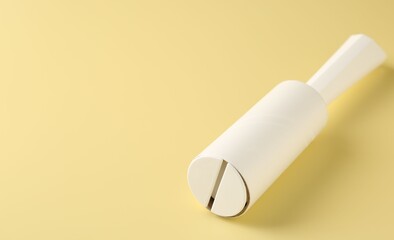 One lint roller on yellow background, closeup. Space for text