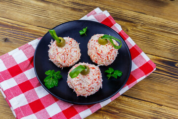 Appetizer of crab-cheese balls made in a shape of Christmas baubles on wooden table. Top view