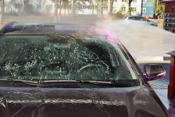 man worker washing car on a car wash