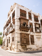 Historic building facade with traditional wooden windows and balconies in Al-Balad, Jeddah, Saudi Arabia.