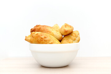 Homemade baked goods. Pies on a plate stand on a table against a white background.