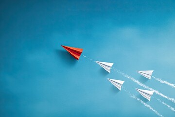Red paper airplane leading four white paper airplanes, symbolic of leadership and direction