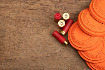 Flying clay pigeon target with shot gun bullet shell on wooden background , Gun shooting game © Suttiwan