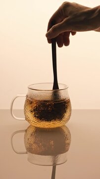 Glass cap with black tea brewing in a cap. 4K Video