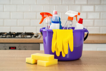 A Collection of Cleaning Supplies in a Purple Bucket with Yellow Gloves and Sponges, Ideal for Home Cleaning and Housekeeping Themed Visuals and Product Mockups