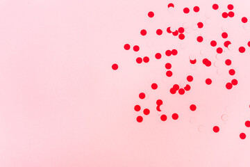 flat lay of red and pink confetti against a pink background with copy space available