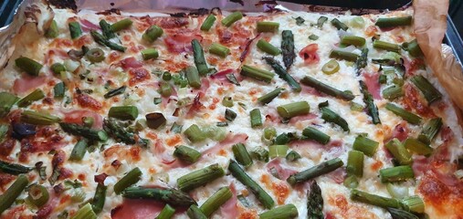 Flammkuchen mit gr&uuml;nem Spargel, Schinken und K&auml;se als Vollbild und Nahaufnahme