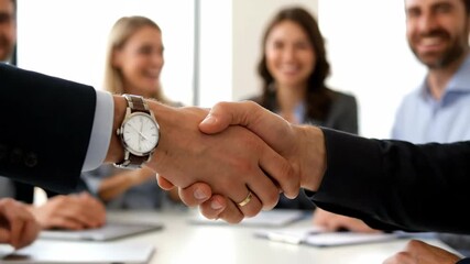 Concept Of Partnership And Business Agreement. Close-Up Of Handshake Between Professionals With Colleagues Applauding In Background - Powered by Adobe