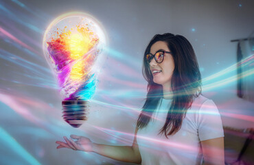 Woman interacting with colorful glowing lightbulb symbolizing digital creativity