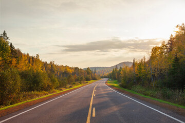 Highway with hills and trees in fall color at sunset in northern Minnesota