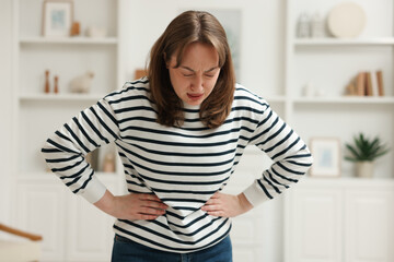 Woman suffering from stomach ache and nausea at home