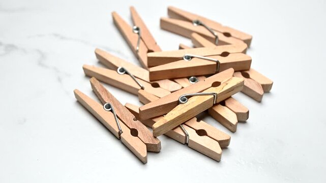 wooden clothes pegs rotating on white surface
