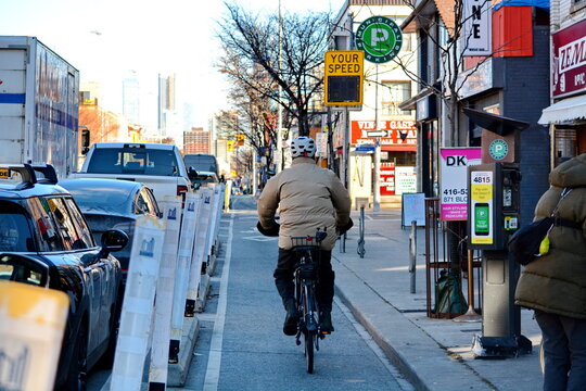 TORONTO, ONTARIO, CANADA - December 12, 2024: Cyclists ride their bikes on the city bike lanes on Bloor Street in downtown Toronto.
