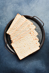 Matzoh jewish bread on a metal tray. Top view, on a gray background.