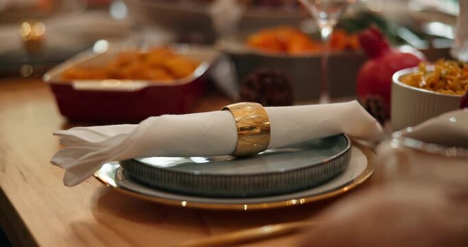 Napkin, table setting and thanksgiving with food in dining room of home for social gathering. Dinner, meal and plate with serviette holder in apartment for celebration, event or holiday tradition
