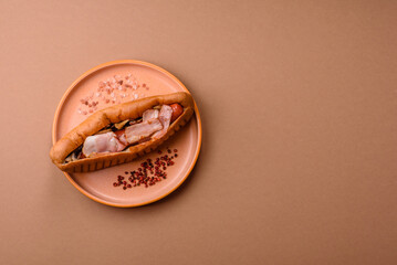 A hot dog with sausage, bacon, sauces, and a bun, unhealthy takeaway food. A hot dog with bacon