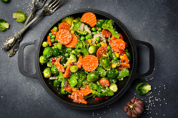 Stewed vegetables with sesame and garlic in a frying pan. Close-up. Organic food.