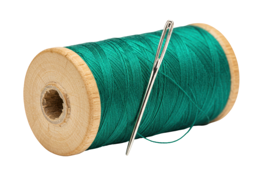 Isolated spool of green thread with needle for sewing or mending clothes and crafts at home