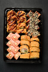 Sushi set. Sushi rolls with fish, caviar and avocado in a plastic disposable dish. Food delivery.