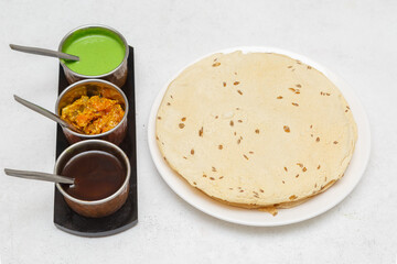 Trois sauces indiennes – verte, piquante et sucrée, servies avec papadum, galette indienne frite à base de farine de haricots urd
