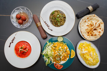 Assortiment de plats indiens – table colorée de spécialités traditionnelles. Vue du dessus d’une table garnie de plusieurs plats indiens colorés. 