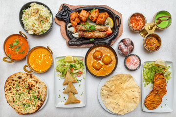 Assortiment de plats indiens – table colorée de spécialités traditionnelles. Vue du dessus d’une table garnie de plusieurs plats indiens colorés. 