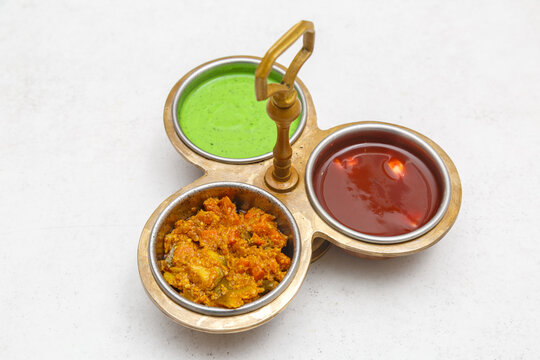 Condiments indiens &ndash; sauce verte (chutney &agrave; la menthe), sauce piquante (pickles/achards) et sauce sucr&eacute;e (chutney au tamarin), photographie culinaire. Sauces indiennes.
