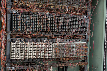 Close up of an old telephone exchange or switchboard, showing a complex connection block and a dense tangle of cables. This electromechanical switching system connected phone lines.