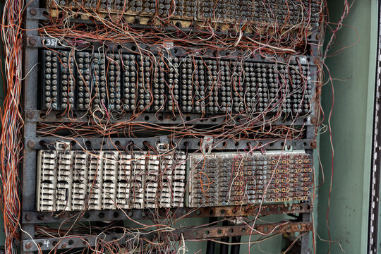 Close up of an old telephone exchange or switchboard, showing a complex connection block and a dense tangle of cables. This electromechanical switching system connected phone lines.