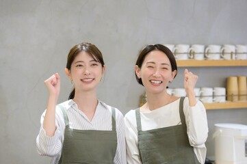 受付でガッツポーズをする日本人女性店員