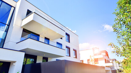 Modern apartment building with balconies and greenery. The structure features a glass wall and lush...