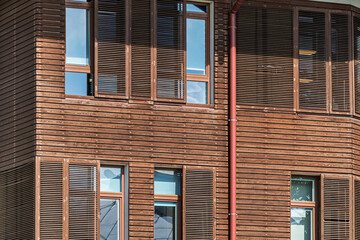 House with wooden plank facade. Building renovation using wood for the facade