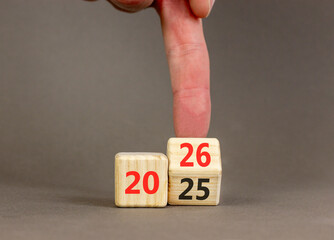 Business concept of 2026 new year symbol. Businessman turns wooden cube and changes number 2025 to 2026. Beautiful grey table grey background, copy space. Business 2026 happy new year concept.
