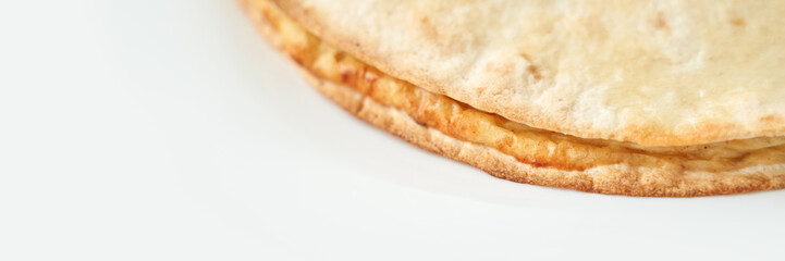 Close-up of a freshly baked golden brown flatbread on white background.