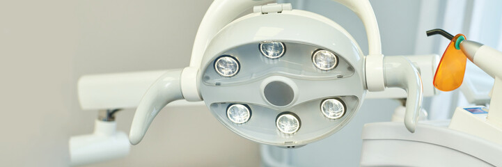 Close-up of dental operating light in clinic setting with adjustable arms and bright illumination for dental procedures.