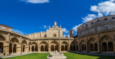 A panoramic view of a sunlit courtyard with a central fountain