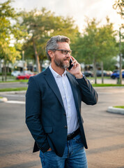 Businessman using phone. Man phone conversation. Hispanic business man with smartphone. Business communication. Man reply phone call. Busy businessman talking on phone outdoor