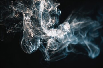 Fototapeta premium Swirling smoke patterns create an abstract design on a dark background in a dynamic visual display