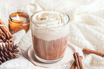 Cozy winter or Christmas concept with coffee (Eggnog Latte) and candle