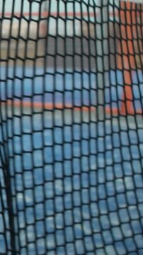Slow motion through grid view of paddle tennis man playing on blue court outdoors. One caucasian padle player sportman hitting the ball. Racquet sport game Concept.