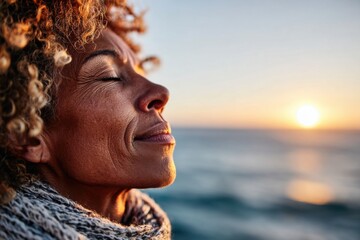 Woman enjoying a peaceful moment by the ocean during sunset with a calm expression and gentle breeze