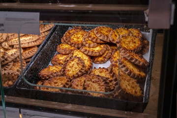 Freshly baked Finnish Karelian pies in bakery display.