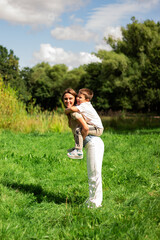 Fototapeta premium Carefree childhood moment. Preschool boy and mom twirl. Ideal for parenting and happiness themes.