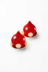 Two red christmas mousse cakes decorated with snowflakes and gold on white background