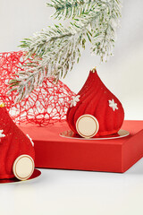 Red christmas mousse cakes decorated with snowflakes resembling santa claus hats