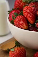 Glass full of strawberries and a glass of milk