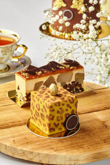Delicious modern cakes with gold and chocolate decorations resting on wooden table