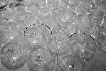 A row of elegant empty wine glasses sparkles in soft focus, creating a refined and festive atmosphere