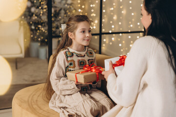 Mother and daughter exchanging christmas gifts at home