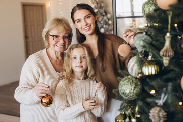 Three Generations Decorating Christmas Tree at Home